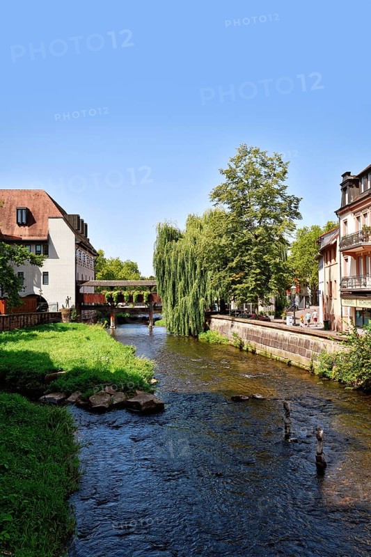Ettlingen, Germany - August 13th 2025: Alb brook in historic center of Ettlingen, Germany. Small creek with old buildings on sunny day
