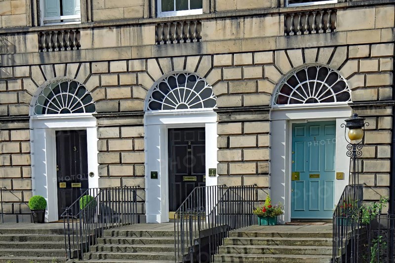 Three Georgian doors with symmetrical windows and stairs in front of them, Newtown, Edinburgh, Scotland, United Kingdom