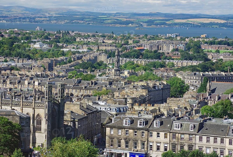 A panorama of buildings and water in a vast cityscape, view from Castle Hill, Edinburgh, Scotland, United Kingdom