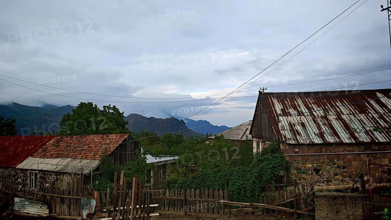View of a rural village with old houses and mountains in the background, romantic atmosphere, Armenia