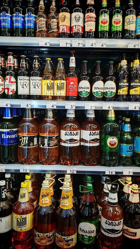 Shelves filled with various beverage bottles, beer selection in a Georgian supermarket, Tbilisi, Georgia