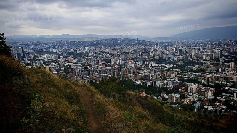 Hiking trail and view from a hill over a vast urban landscape, Tbilisi, Georgia