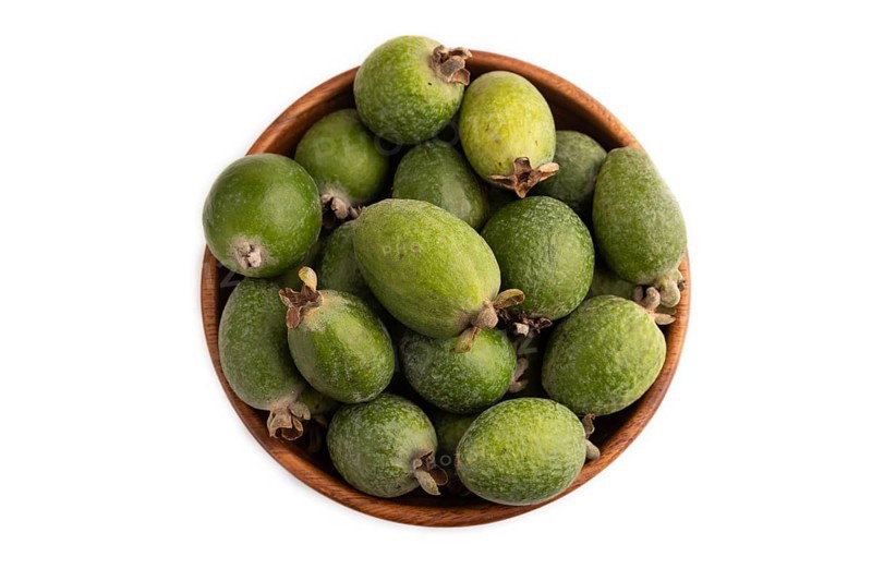 Ripe Feijoa in wooden bowl isolated on white background, top view, flat lay, close up, minimalism