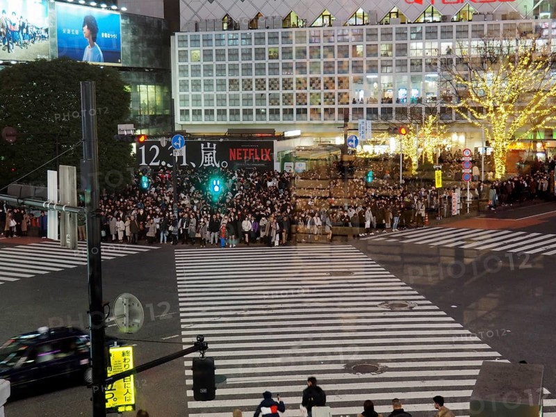 Crowds of people at night at a busy urban crossroads, Shibuya, Tokyo, Japan
