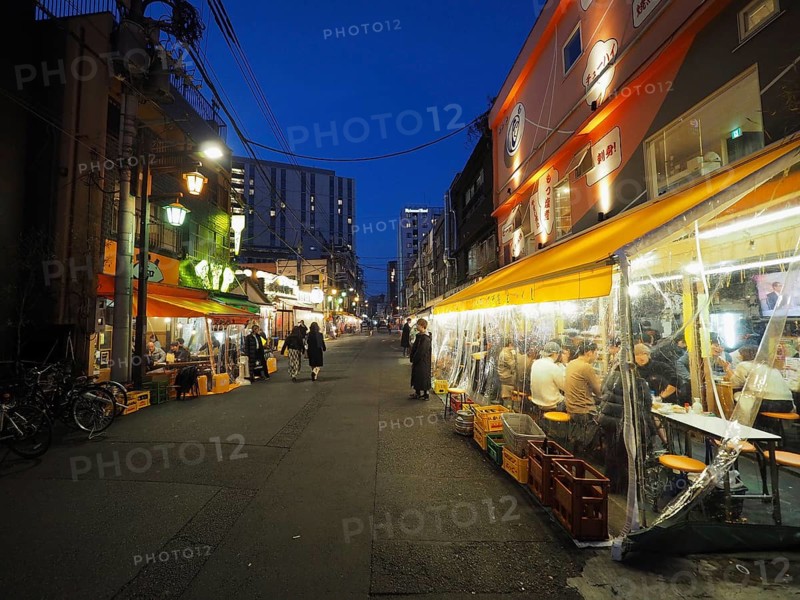 Narrow street at night with brightly lit restaurants and relaxed atmosphere, Nishi-Asakusa, Tokyo, Japan