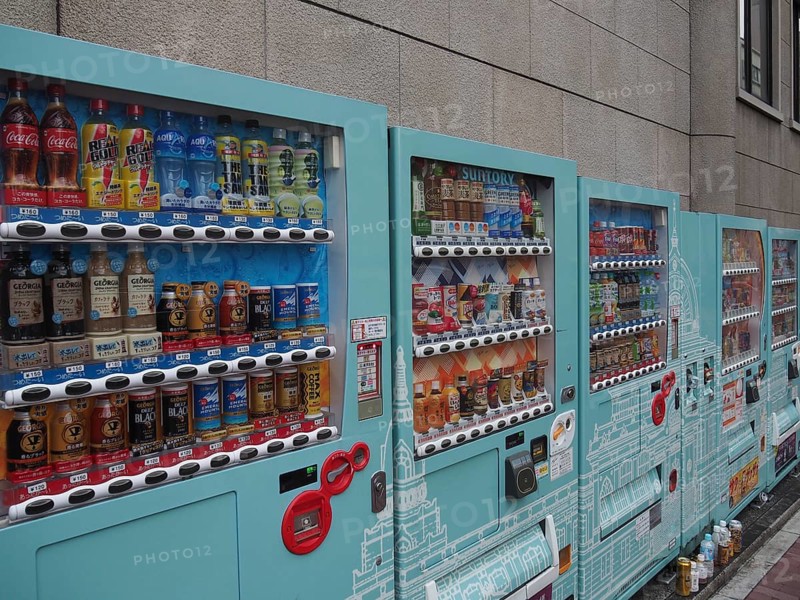 Row of colorful vending machines on a gray wall with a wide selection of drinks, Tokyo, Japan