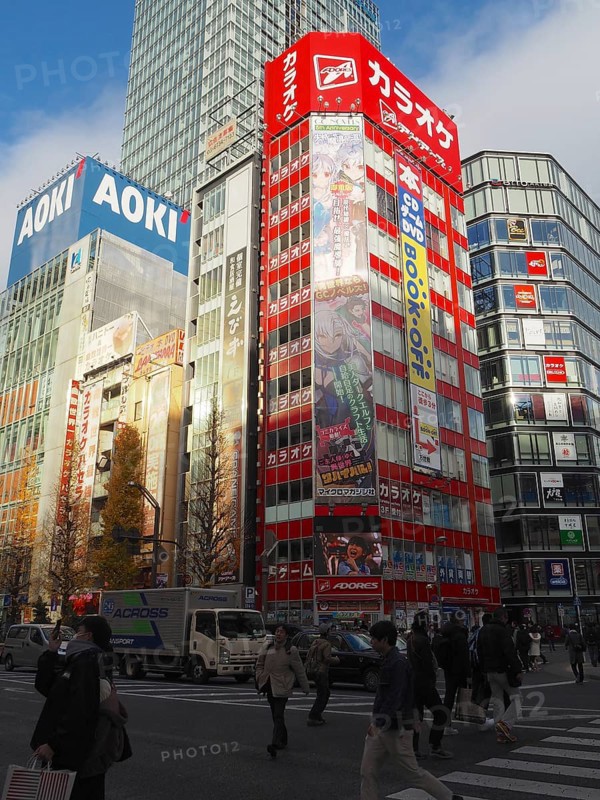 Bustling city street with tall buildings and colorful billboards in daylight, Akihabara Electric Town, Tokyo, Japan
