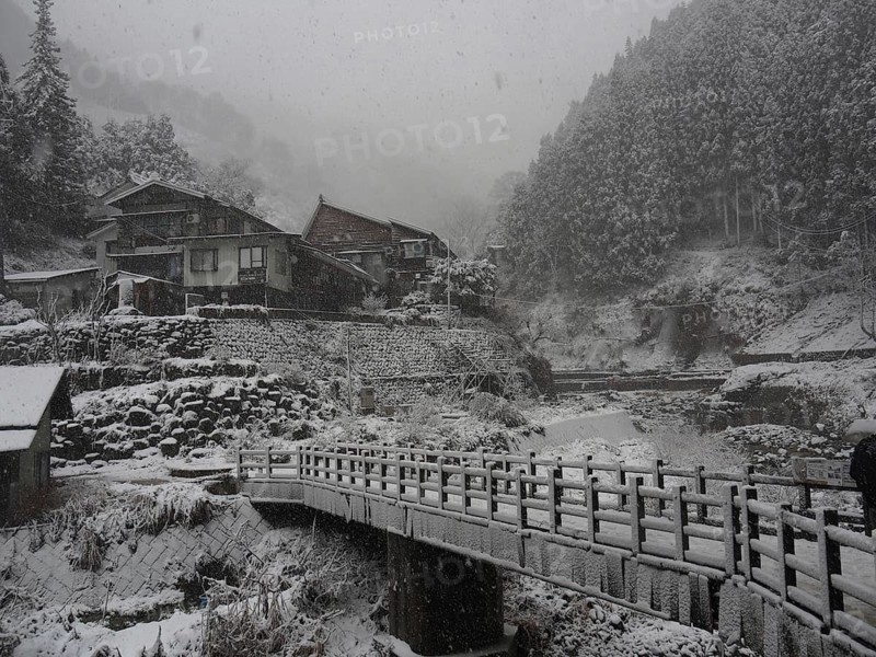 Snowy mountain village with stone bridges and traditional houses in winter peace, Kambayashi Onsen, Nagano, Japan