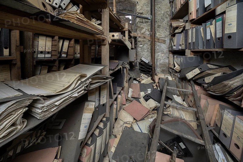 Shelves with dusty folders in the administration of a former GDR factory, Lost Place, Saxony-Anhalt, Germany