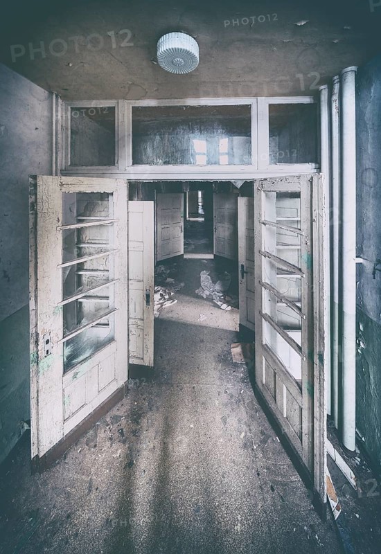 Double door, long corridor and open doors in a former sanatorium, Lost Place, Saxony-Anhalt, Germany