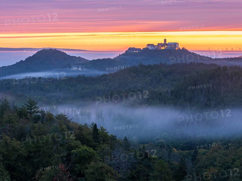 View from Rennsteig across the Thuringian Forest to Wartburg at dawn, morning fog in the valleys, near Eisenach, Thuringia, Germany
