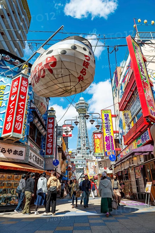 Lots of colorful signs in a pedestrian zone with shops and restaurants, behind Tsutenkaku Tower, Shinsekai, Osaka, Japan