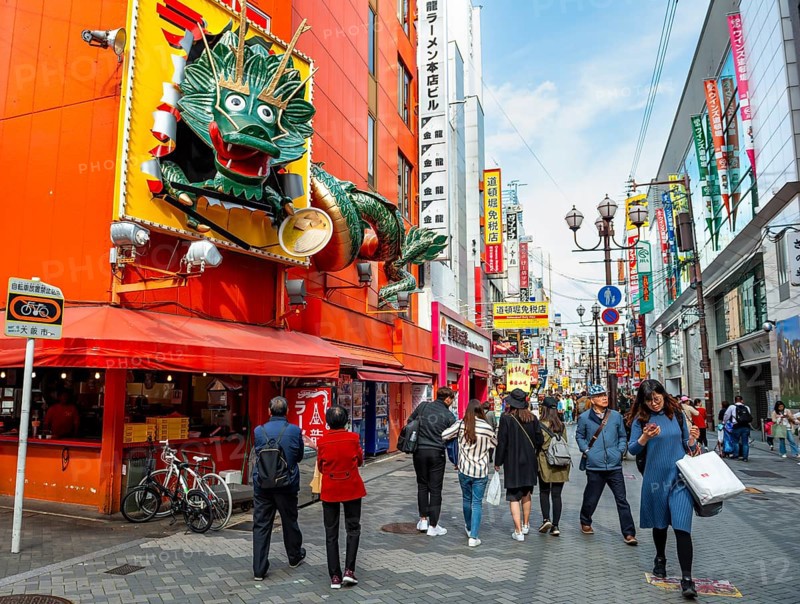 Dragon figure at a restaurant, lots of colorful signs in a pedestrian zone with shops and restaurants, Dotonbori, Osaka, Japan