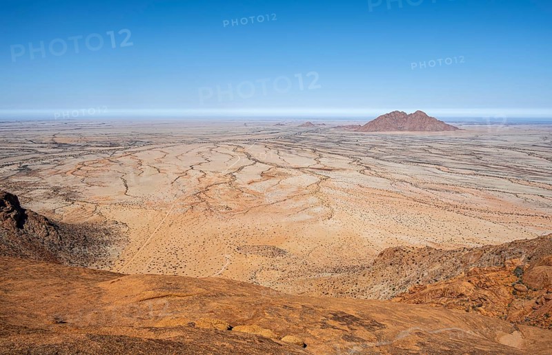 Wide desert landscape with rocky hills and bright blue sky in Spitzkoppe, Spitzkoppe, Namibia