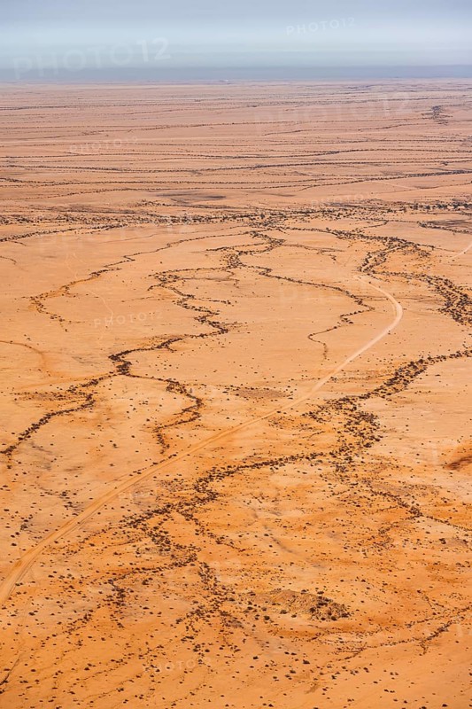 Aerial view of a vast, dry desert with distinctive soil patterns, Spitzkoppe, Namibia