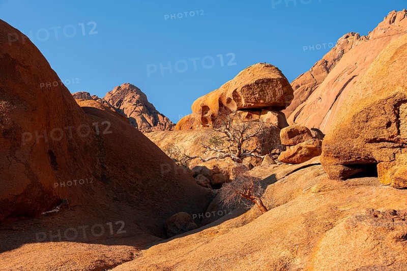 Rocky landscape with orange rocks under clear blue sky, Spitzkoppe, Namibia