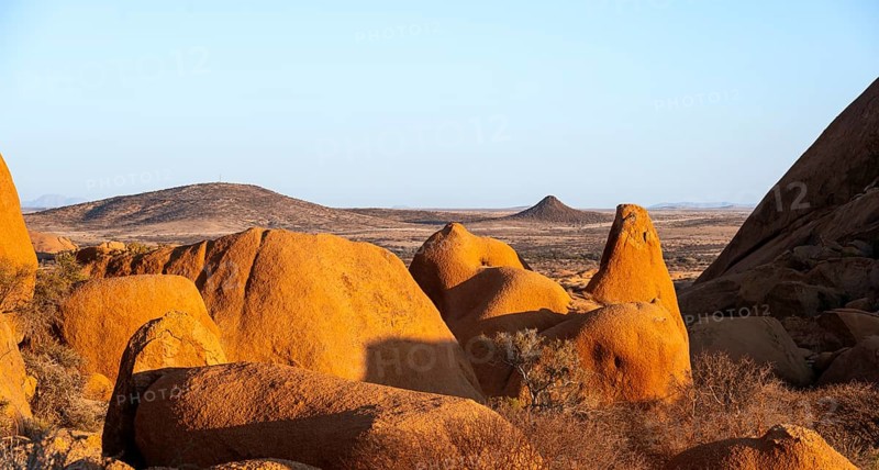 Extensive rock formations and barren desert landscape under clear skies in Spitzkoppe, Spitzkoppe, Namibia
