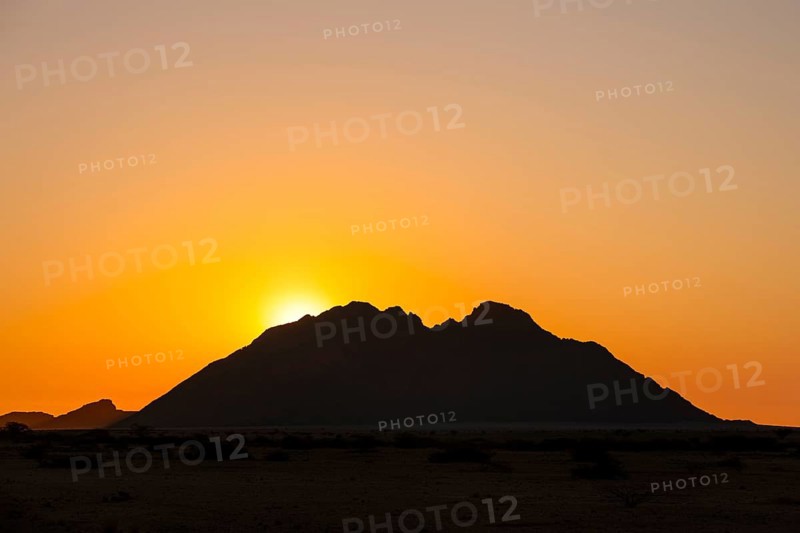 Sunset behind a distinctive mountain silhouette in the wilderness of Spitzkoppe, Spitzkoppe, Namibia