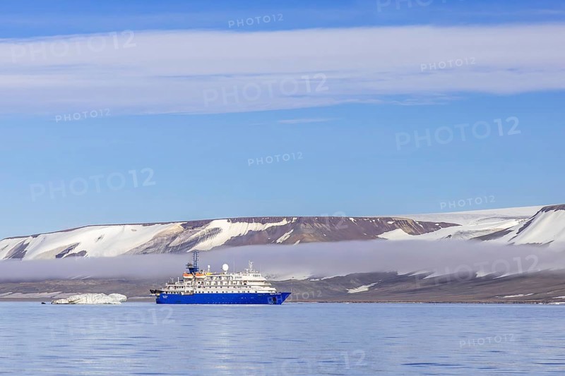 Antarctic cruise ship MV Sea Spirit of Poseidon Expeditions with eco-tourists cruising along the coast of Svalbard / Spitsbergen in summer