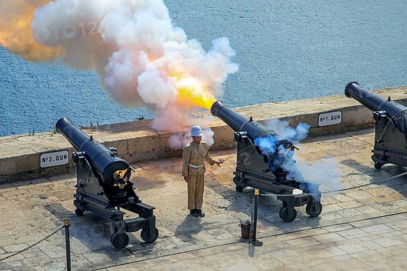 Soldier firing cannon salute with SBBL 32-pounder gun at 16th century Saluting Battery at Grand Harbour in capital city Valletta on the island Malta