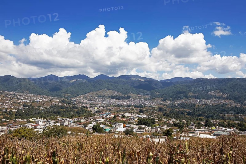City view of Nahualá between green mountains, in front of a corn field, highlands, Sololá Department, Guatemala