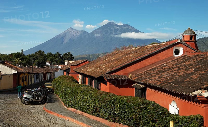 Traditional houses in a cobblestone alley with the Fuego volcano in the back, Old Town, Antigua, Highlands, Sacatepéquez Department, Guatemala