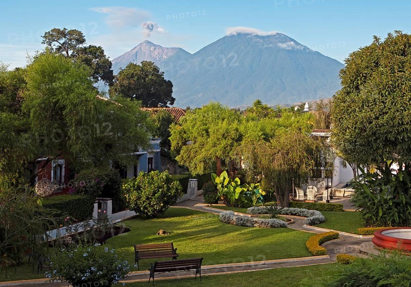 Garden of the Hotel Villa Colonial in the old town, the smoking volcano Fuego in the back, Antigua, Highlands, Sacatepéquez Department, Guatemala