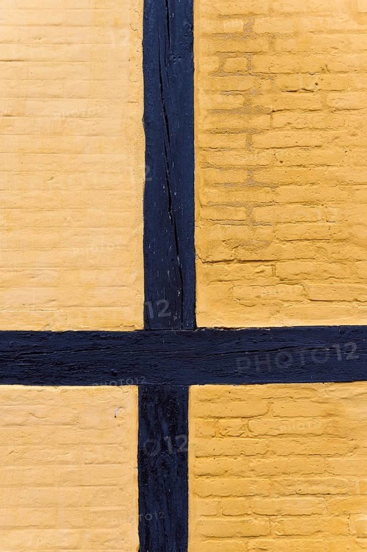 Detailed view of a yellow half-timbered façade with black wooden beams, nave, reconstructed courtyard with nine houses of a large farmer from the Viking Age, Fyrkat Viking farm, Hobro, Denmark