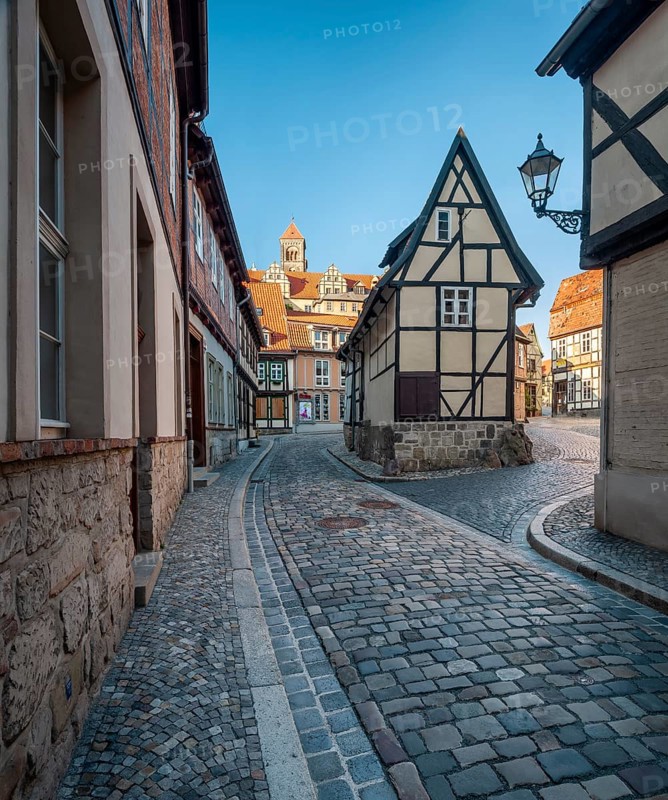 Narrow alley with half-timbered houses and cobblestones at Finkenherd in the historic old town, in the back the Schlossberg with the collegiate church of St. Servatius, UNESCO World Heritage Site, Quedlinburg, Saxony-Anhalt, Germany