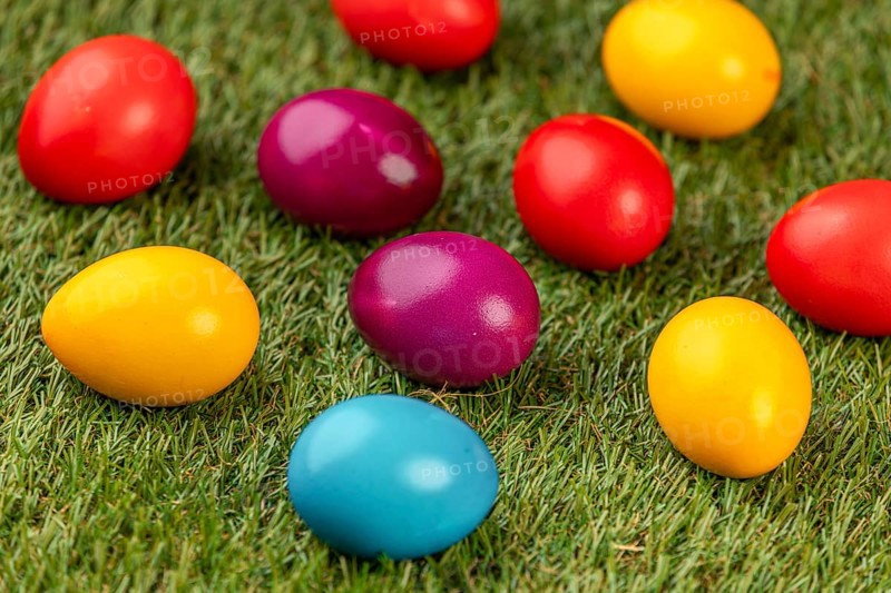 Colourful Easter eggs spread on green grass