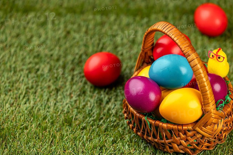 A basket full of colorful Easter eggs on a grassy area