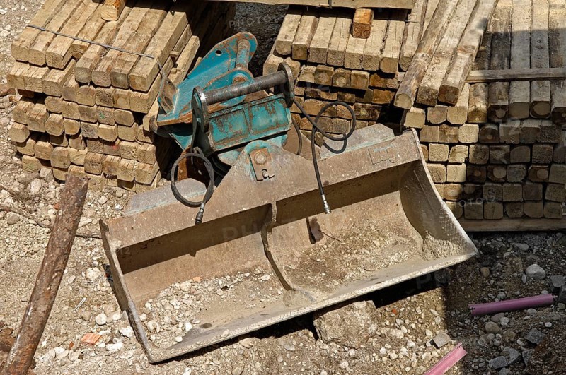 Wooden beam and shovel of an excavator on a construction site