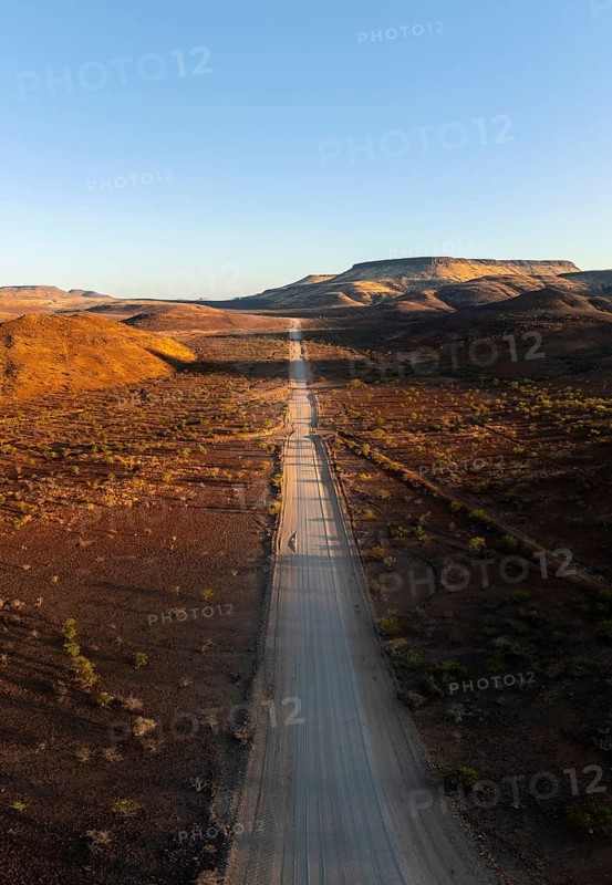 Aerial view, infinite space, straight road leads through dry desert landscape, hills in Damaraland, Namibia