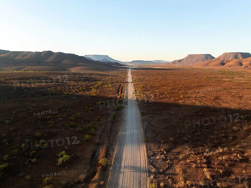 Aerial view, infinite space, straight road leads through dry desert landscape, hills in Damaraland, Namibia
