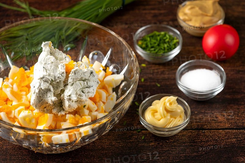 Cream cheese and ingredients for egg cream placed in a bowl