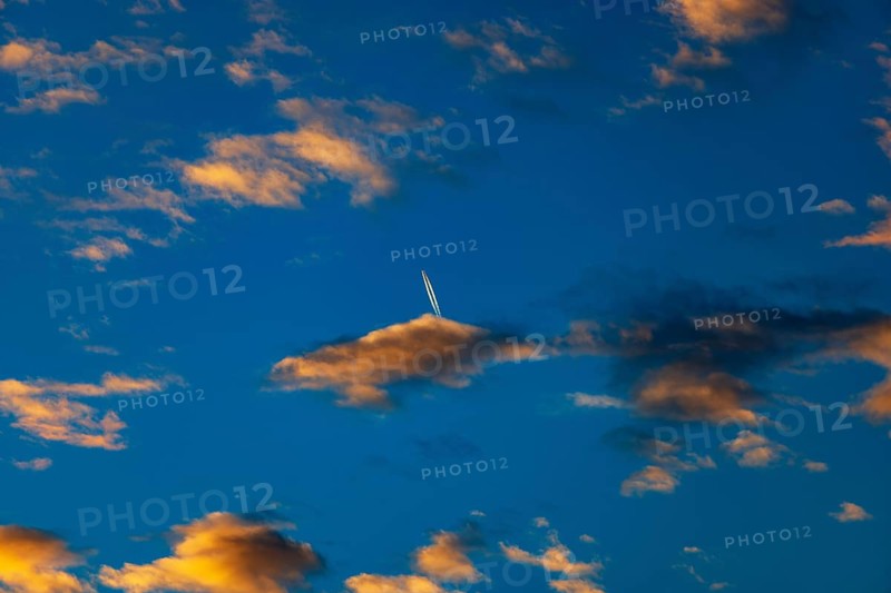 Aircraft contrails with red clouds, sunrise, Upper Austria