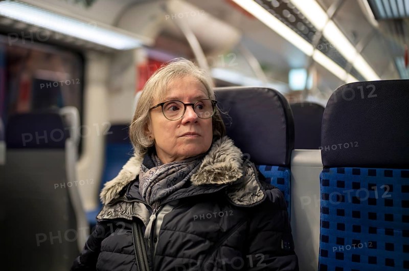 Elderly woman, portrait, thoughtful, glasses, gray hair, coat, scarf, winter clothes, sitting in the S-Bahn, Stuttgart, Baden-Württemberg, Germany