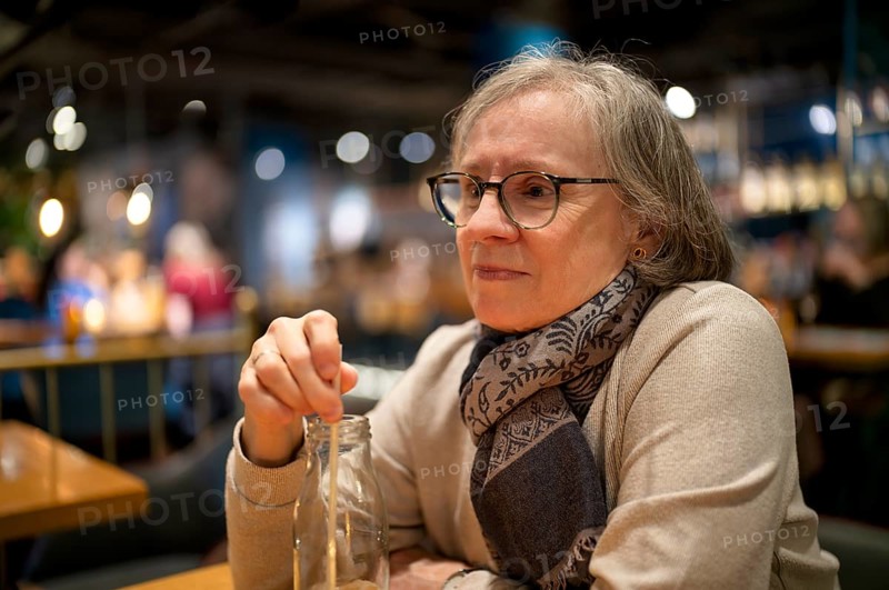 Elderly woman, portrait, glasses, gray hair, scarf, drink, straw, sitting in a bar, restaurant, Stuttgart, Baden-Württemberg, Germany