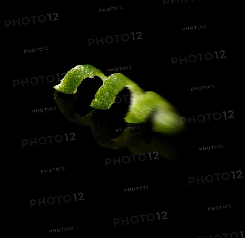 Lime zest against black background, motion blur, studio shot