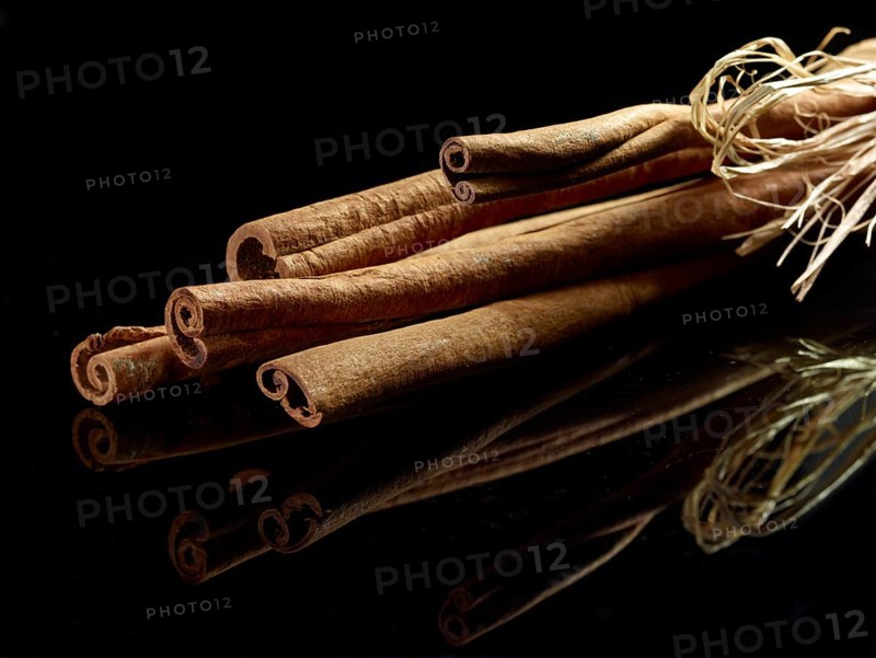 Several cinnamon sticks (Cinnamomum sp.) in front of a black background, studio shot