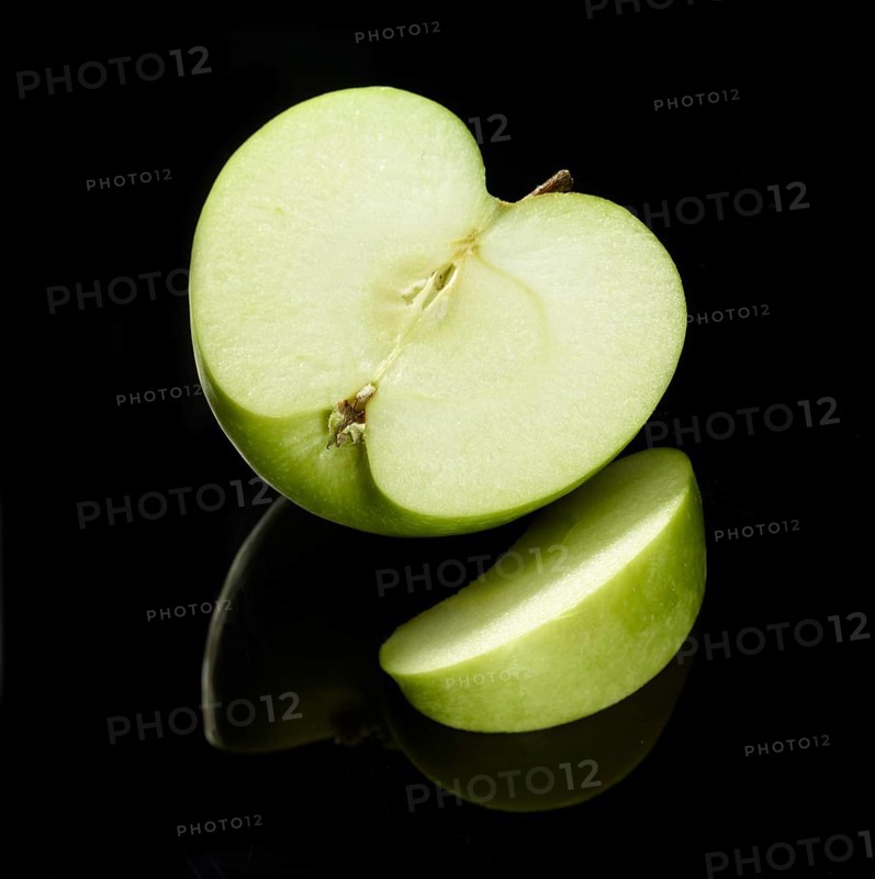 Apple, apple half and apple cleft (Malus domestica) in front of a black background, studio shot