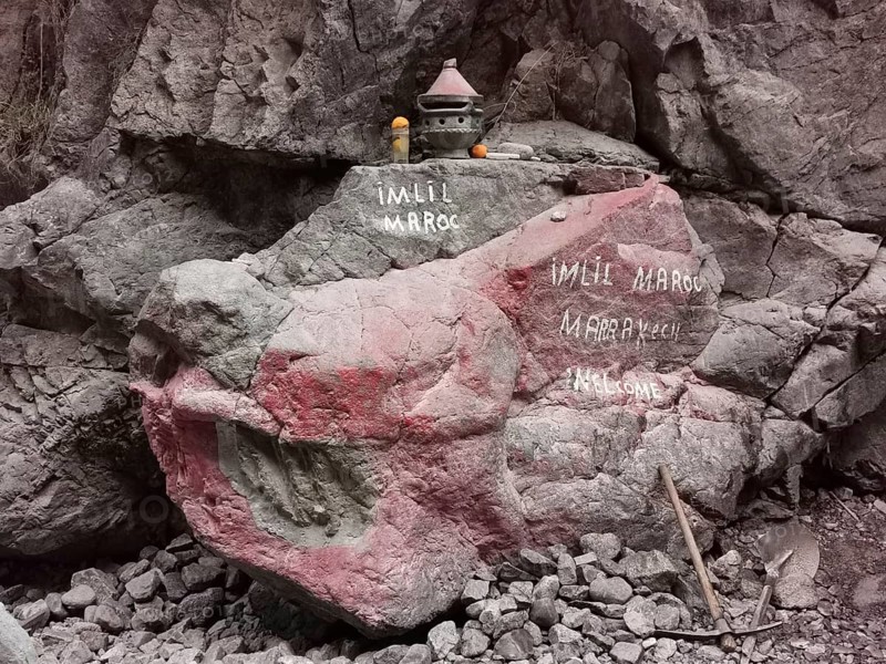 A rock with red and white inscriptions and small decorative objects, welcome, Atlas, Imlil, Morocco