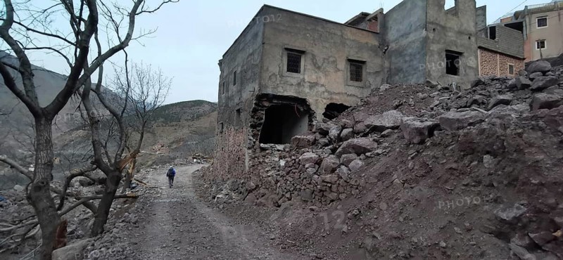 Dilapidated, collapsed buildings following an earthquake in the Atlas Mountains, on a lonely, barren road, Morocco