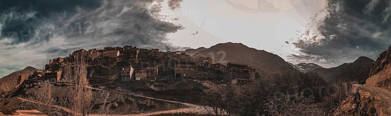 A dramatic panorama of a mountain village with dark clouds in the sky, Atlas Mountains, Morocco