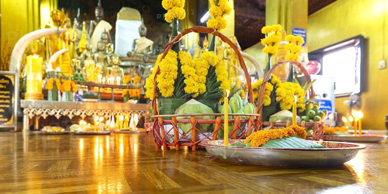 Sacrifices with candles, in front of numerous Buddhas and the City Pillar, which is considered the home of the city's protective spirit, Wat Si Muang temple complex, Vientiane, Laos
