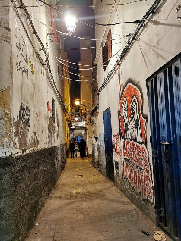 Narrow alley at night, illuminated with walls covered with graffiti and urban flair, Medina, Casablanca, Marakesh