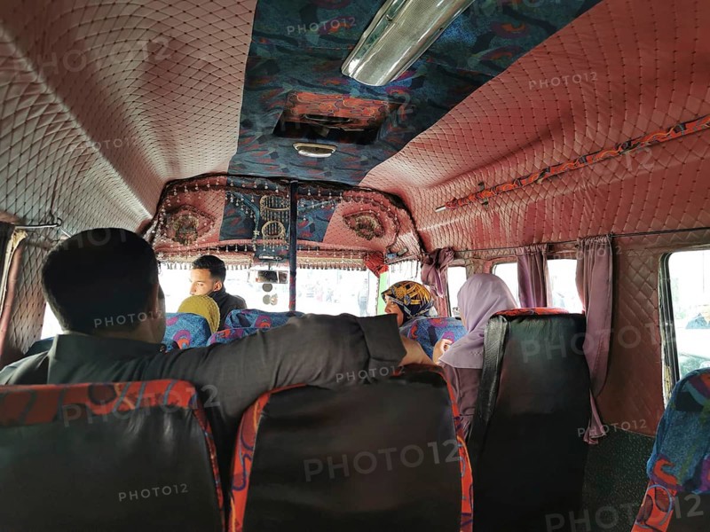 People sitting and talking in the interior of a colorful old bus, Morocco