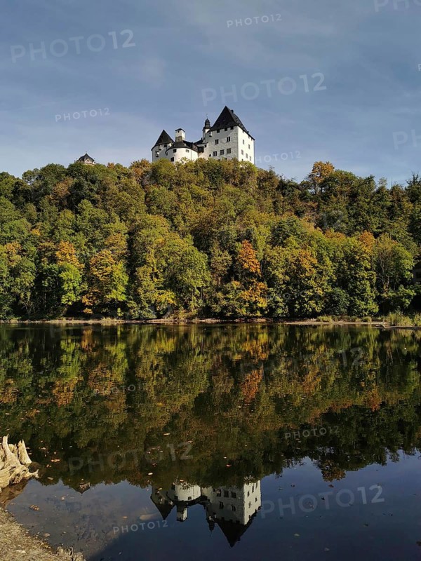 Burgk Castle is reflected in the calm water of the Saale, Thuringian Forest