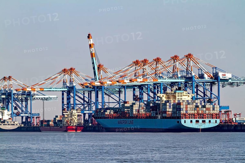 Large cargo ship loaded with containers surrounded by blue port cranes, The cranes of the Bremen industrial port