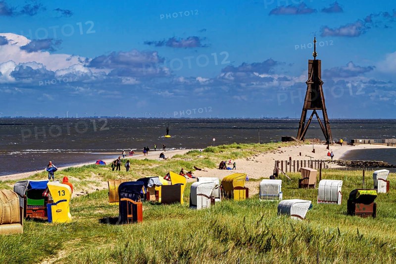 Beach on the North Sea coast with lighthouse and beach chairs under a blue sky, beach chairs on the beach in Cuxhaven